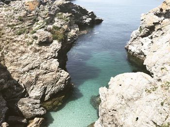 High angle view of rock formation in water against sky