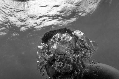 Close-up of man blowing bubbles underwater