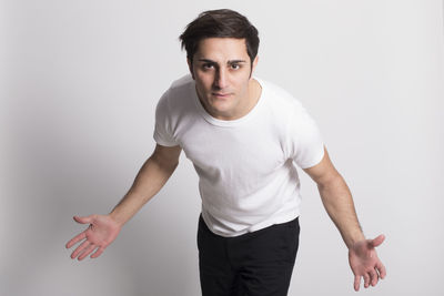 Portrait of young man standing against white background