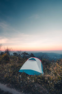 Tent on field against sky during sunset