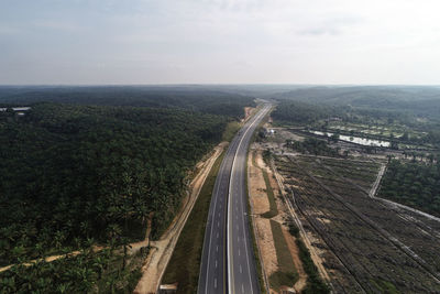 High angle view of road amidst trees against sky