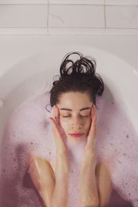 High angle view of woman bathing in bathtub