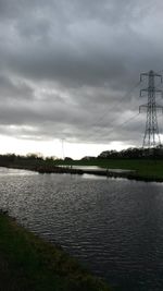 Electricity pylon on landscape against cloudy sky