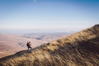 Man standing on grass against sky