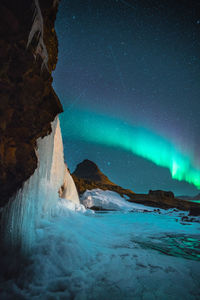 Scenic view of snowcapped mountains against sky at night