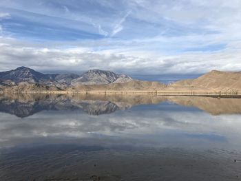 Scenic view mountain range and sky reflecting off of lake