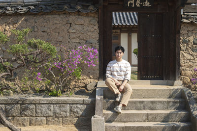 Portrait of young man sitting on staircase