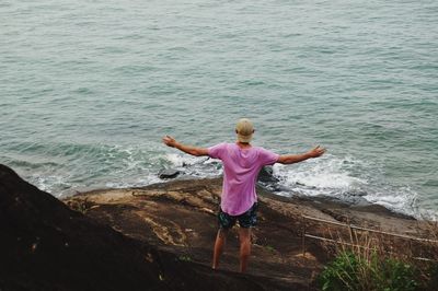 Rear view of boy standing in sea