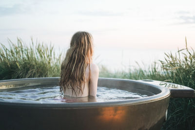 Rear view of woman swimming in water