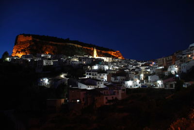 Illuminated cityscape against clear sky at night