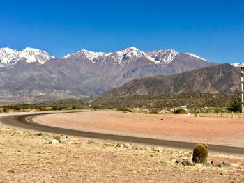 Scenic view of snowcapped mountains against clear blue sky
