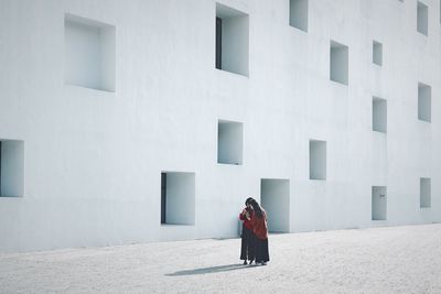 Full length rear view of woman walking in building