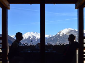 Couple enjoying breakfast at restaurant against french alps