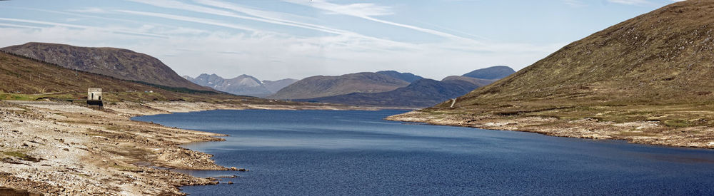 Scenic view of sea and mountains against sky