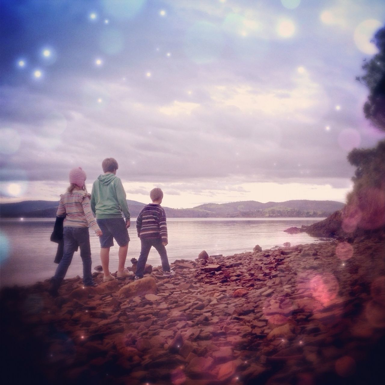 water, lifestyles, sky, togetherness, leisure activity, beach, rear view, cloud - sky, sea, standing, shore, full length, bonding, love, nature, childhood, tranquility, beauty in nature