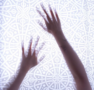 Low section of person touching shadow on wall