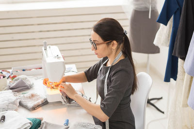 Side view of fashion designer working at studio