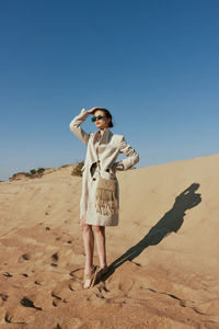 Full length of young woman standing at beach