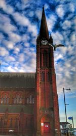 Low angle view of clock tower against cloudy sky