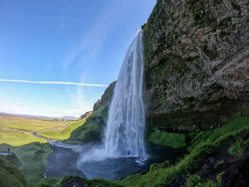 Scenic view of waterfall against sky