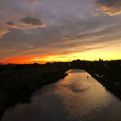 Scenic view of river against orange sky