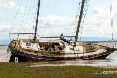 Sailboats moored on sea against sky