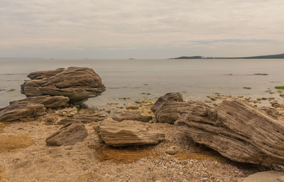 Rocks on beach against sky