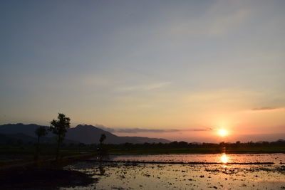 Scenic view of lake against sky during sunset