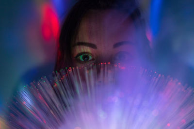 Close-up portrait of young woman with fiber optic