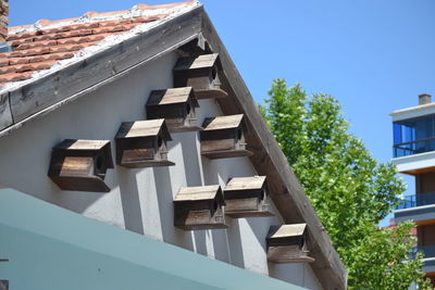 Low angle view of building roof against clear blue sky