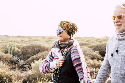 Smiling senior couple standing against sky