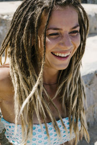 Close-up of cheerful young woman with dreadlocks