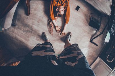 Low section of woman on hardwood floor at home