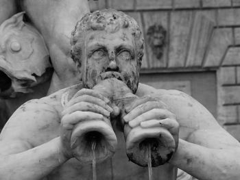 Close-up of statue of man holding sculpture