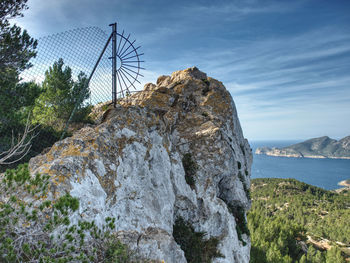 Rock formation by sea against sky