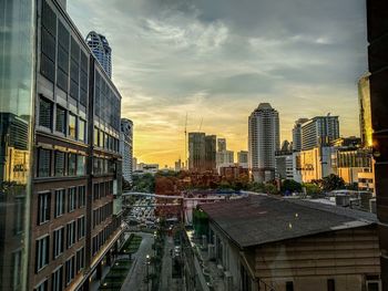 Modern buildings in city against sky during sunset