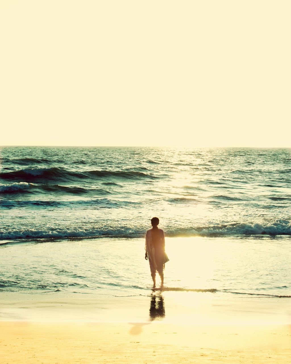 REAR VIEW OF MAN WALKING ON BEACH