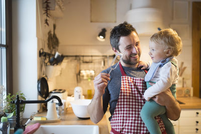 Father and baby boy in kitchen baking a cake