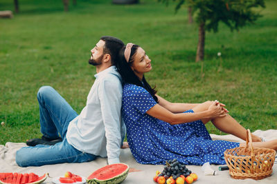 Young couple sitting on field