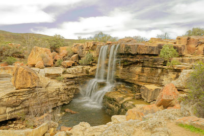 Scenic view of waterfall against sky