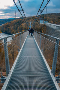 Rear view of people walking on footbridge