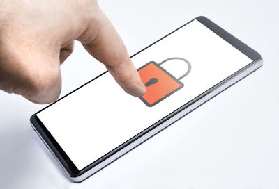 Low angle view of man using smart phone against white background