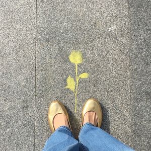 Low section of person standing on yellow shoes