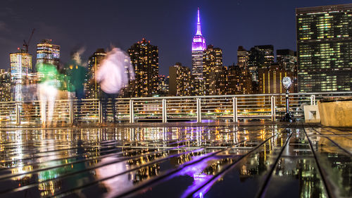 Illuminated empire state building seen from terrace in city at night