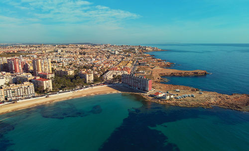 High angle view of sea and buildings against sky