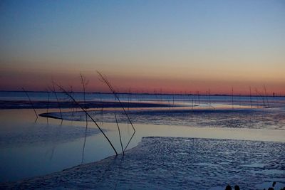 Scenic view of sea against clear sky at sunset