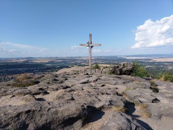 View of cross on land against sky