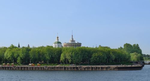 Scenic view of river by building against clear sky