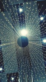 Low angle view of illuminated lighting equipment hanging on ceiling