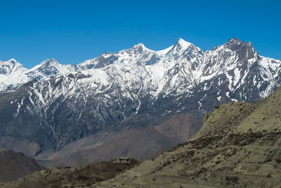 Scenic view of snowcapped mountains against clear sky